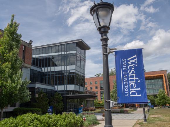 Exterior of Ely Campus Center with a Westfield State University flag on a nearby light post.
