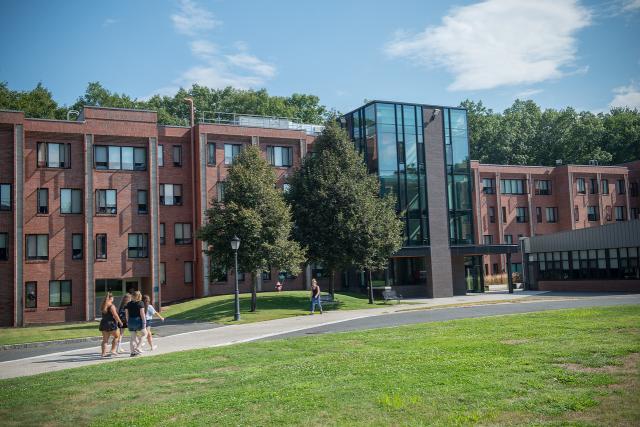 Exterior of Davis Hall on a sunny day, with students walking on the pathway outside.