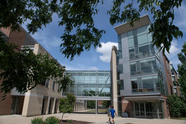 Exterior of New Hall with two students walking into the building.