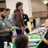 Students talk to people at tables